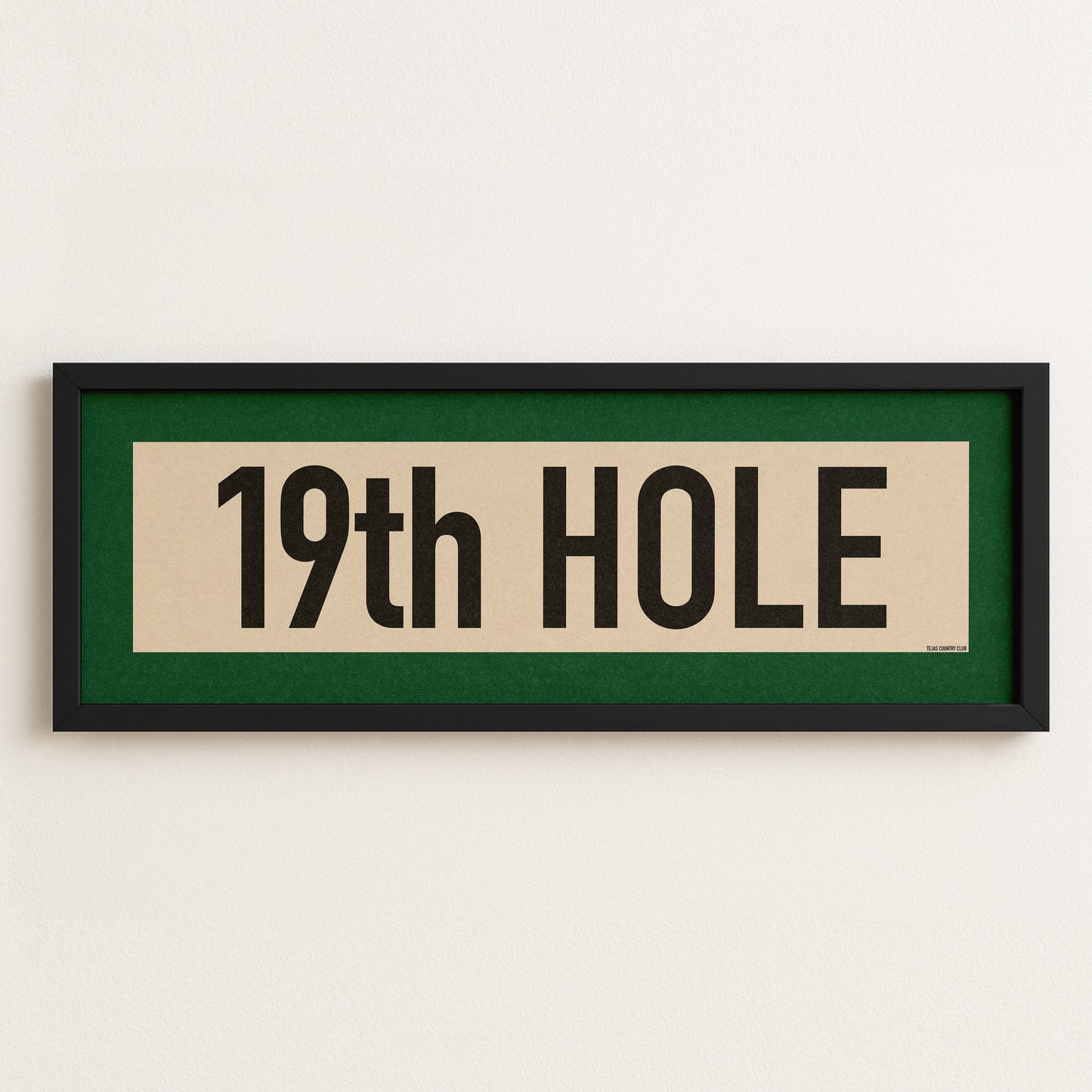 Framed sign with '19th Hole' text on a white wall