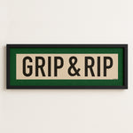 Framed sign with 'GRIP & RIP' text on a white wall