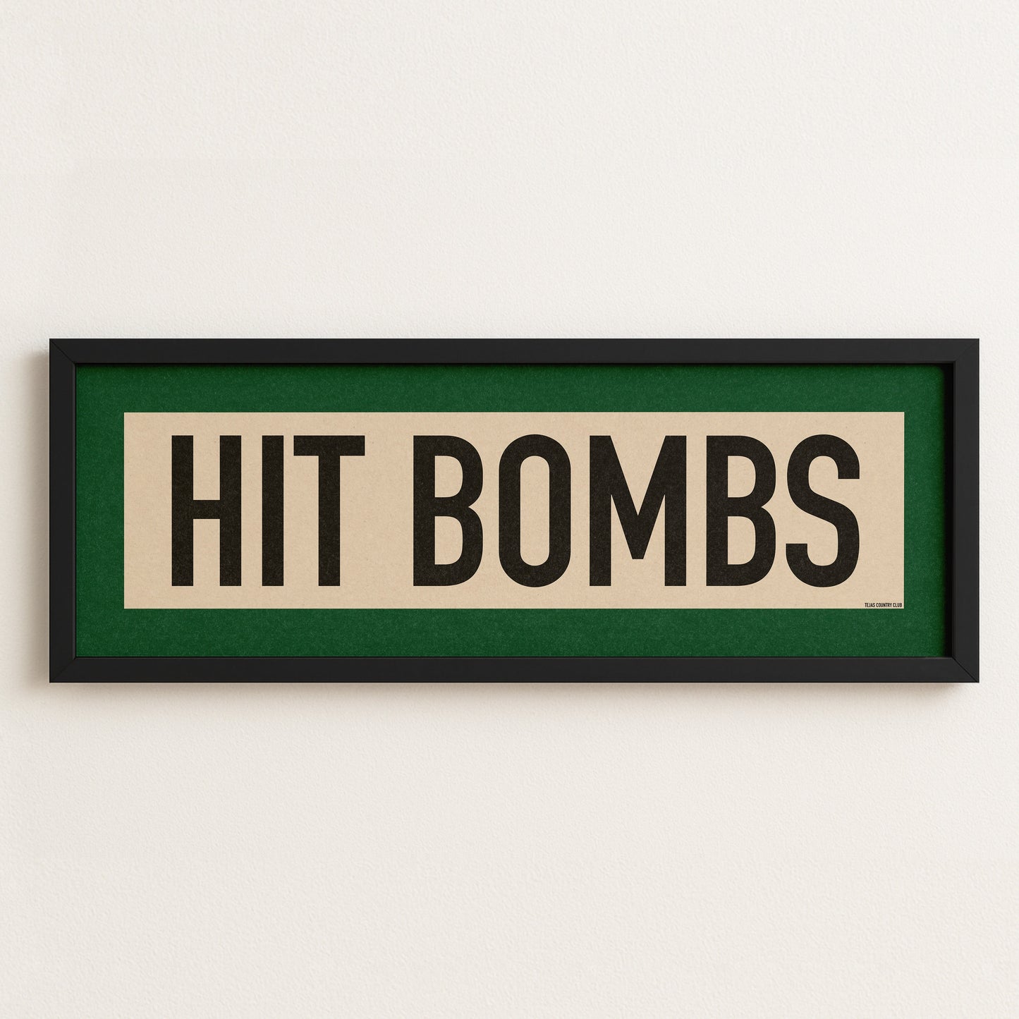 Framed sign with 'HIT BOMBS' text on a white wall