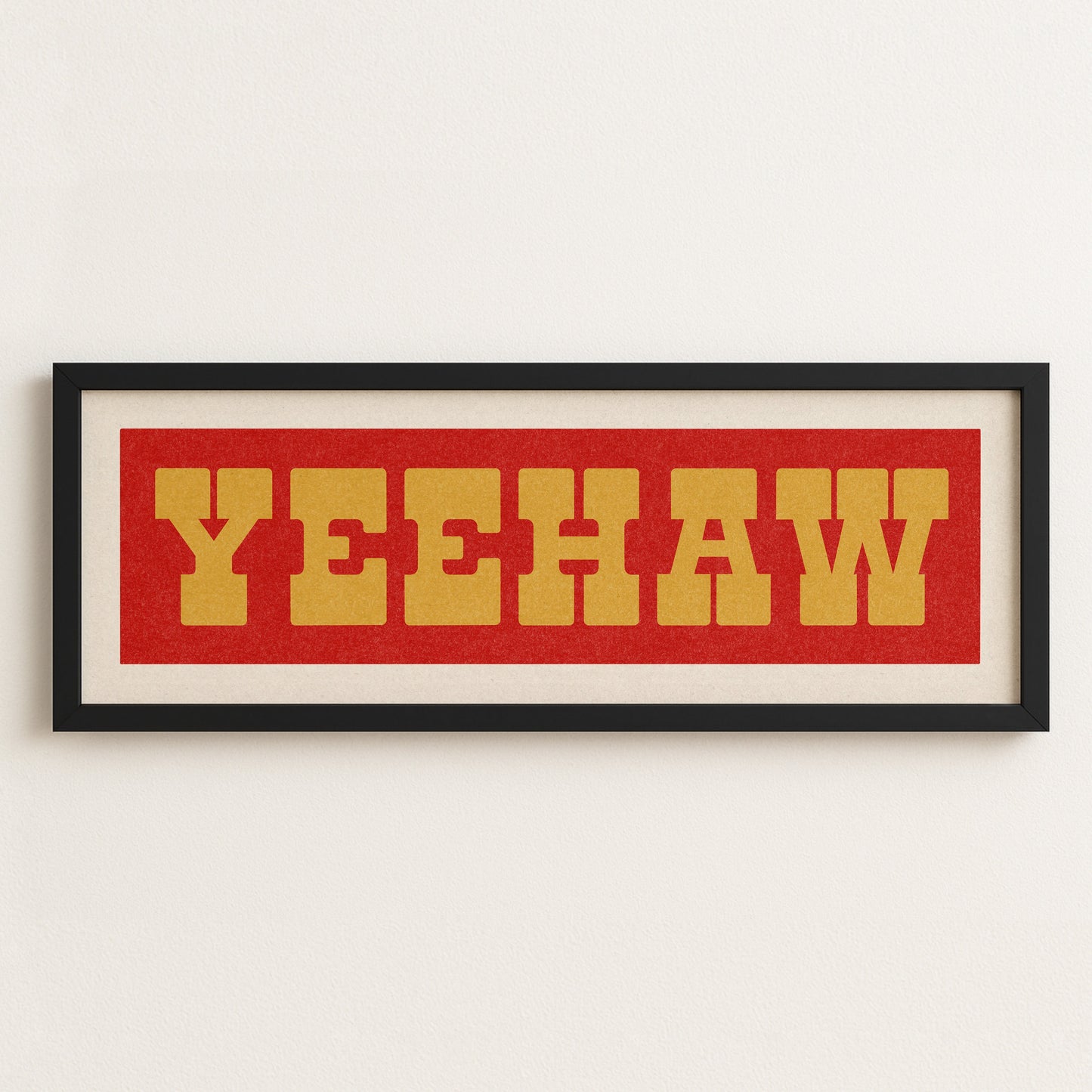 Framed artwork with 'YEEHAW' text on a red background